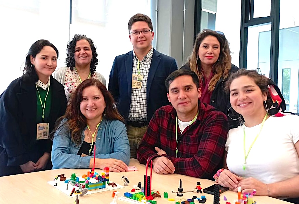 Foto de Alejandra Marinovic con los integrantes del  espacio de construcción colectiva con LEGO® Serious Play®.