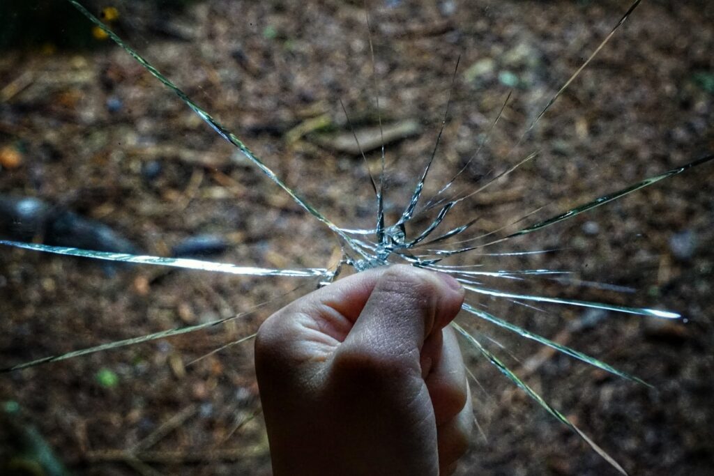 Foto de un puño rompiendo un vidrio en el centro.