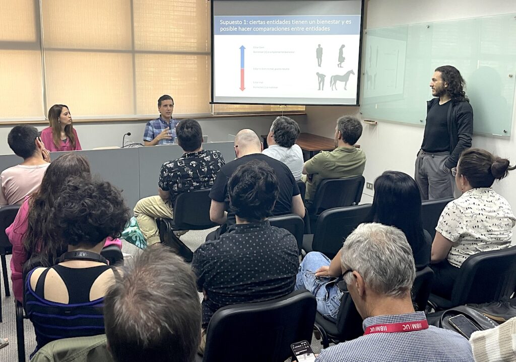 Foto del académico Bernardo Aguilera junto a la académica Constanza Guajardo, y los asistentes a la conferencia.