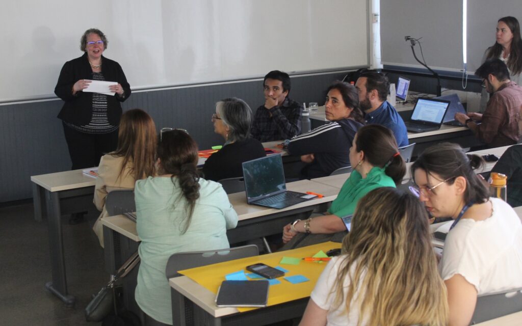Foto de la académica Sarah Eaton en el workshop de docentes junto a los asistentes.