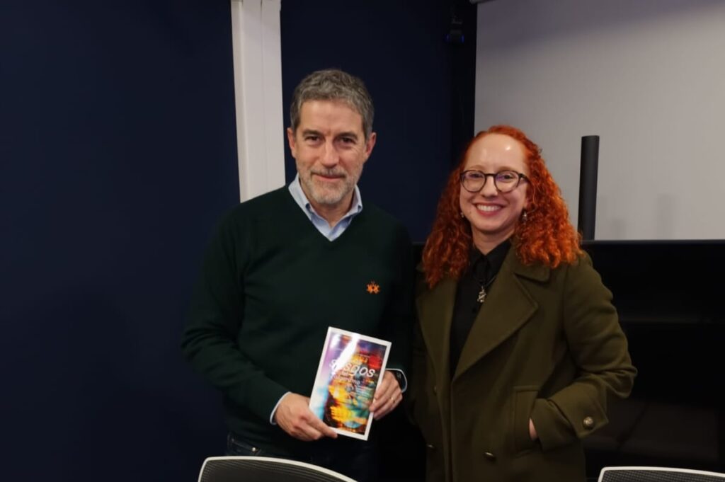 Foto del periodista Polo Ramírez con el libro Los sesgos del algoritmo en las manos junto a la académica Gabriela Arriagada, autora del libro.