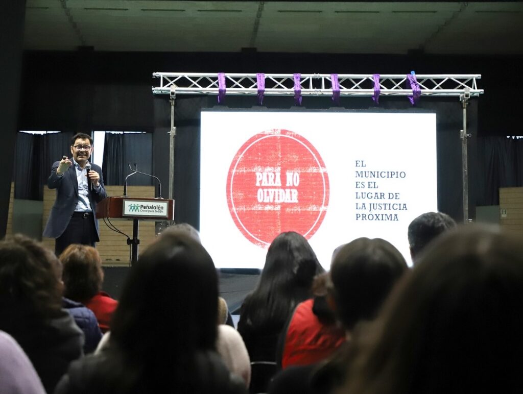 Foto del académico Mauricio Correa en su presentación en el lanzamiento del código de ética de la Municipalidad de Peñalolén junto a los asistentes.