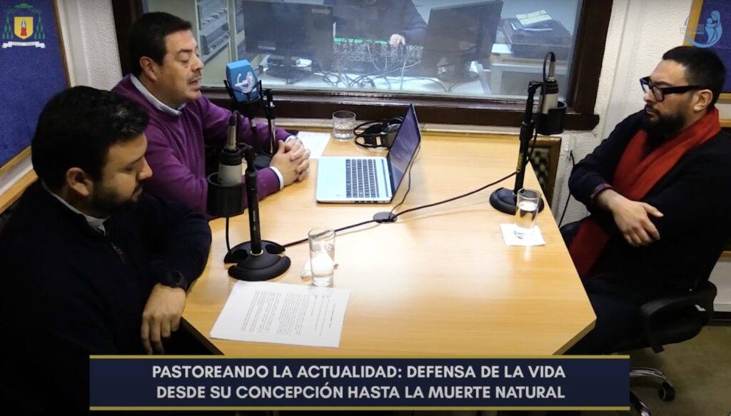 Print de pantalla de la entrevista de , Hans Kittsteiner y el Presbítero Sebastián Vásquez, al académico del Instituto de Éticas Aplicadas, Fernando Arancibia.