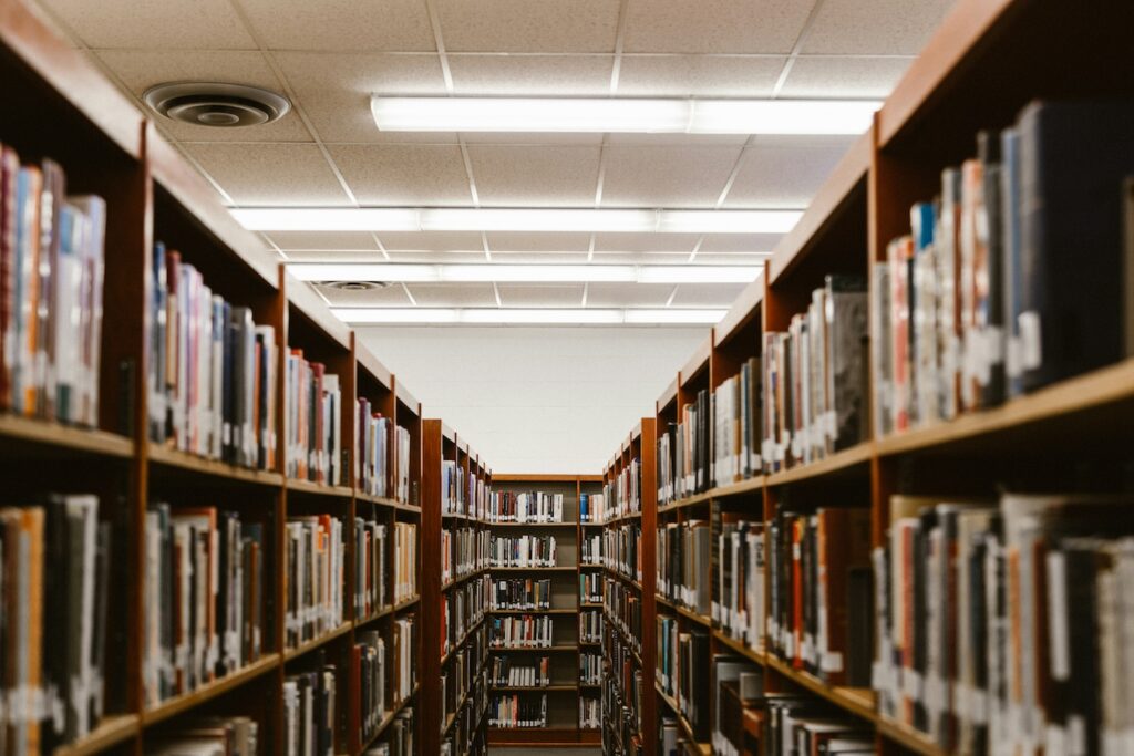 Foto de el pasillo de una biblioteca, con estantes por ambos costados, llenos de libros.