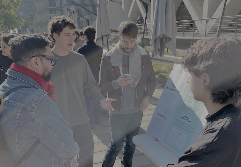 Foto del académico del IEA UC Fernando Arancibia, evaluando el trabajo de los estudiantes del curso Ética para Ingeniería en la Feria de Pósters.