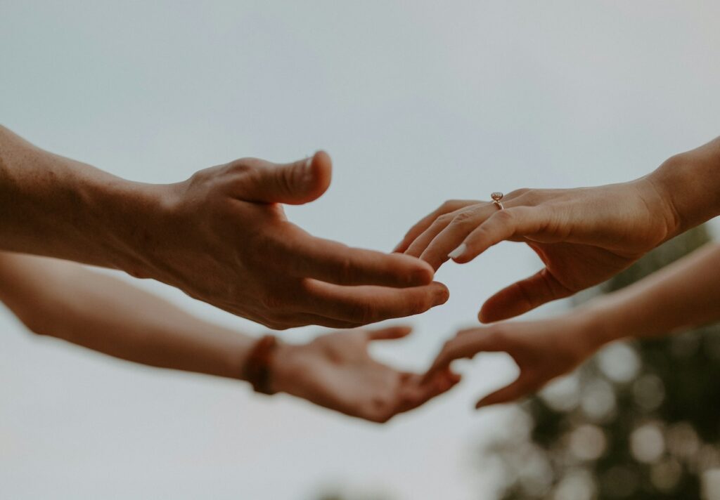 Foto de manos de hombres y mujeres que están a punto de tocarse.