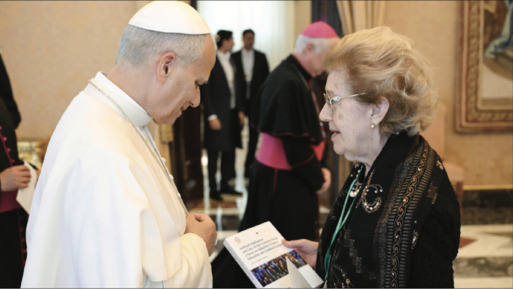 Foto del Papa León XIV junto a Anna Maria Tarantola, quien le hace entrega del libro.