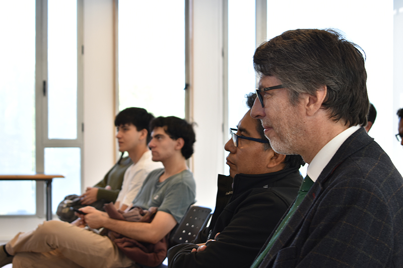 Foto del académico Crisitián Hodge y de los asistentes a la conferencia “La pobreza como problema humano: Relaciones de escasez entre bienes materiales, racionales y espirituales”.