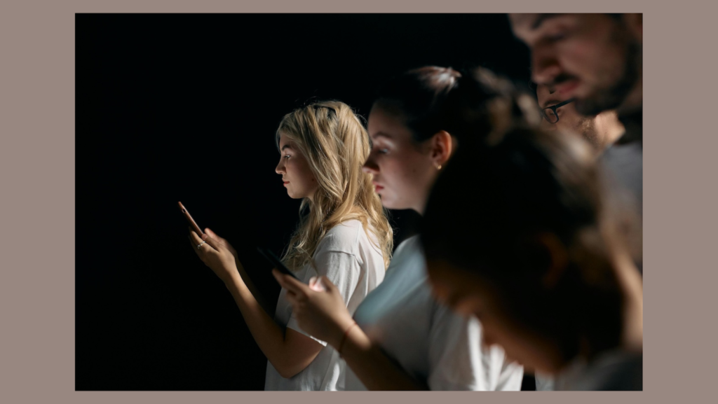 Gráfica con el fondo naranjo pálido y en el centro una foto con fondo negro y, esde el centro hacia la derecha, hay mujeres y hombres, unos al lado de otros, mirando sis teléfonos.