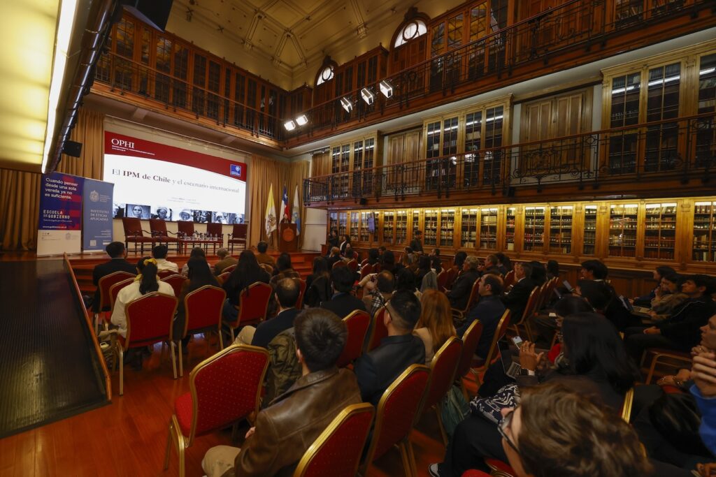 Foto de la Dra. Sabina Alkire en su presentación y los asistentes.